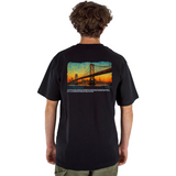 Person wearing a black t-shirt with a golden gate bridge design on the back featuring san francisco