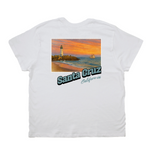 White t-shirt with a graphic of a lighthouse and sunset over water, featuring 'Santa Cruz California' text.