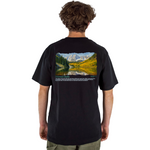 Person wearing a black t-shirt with a scenic landscape design on the back