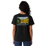 Person wearing a black t-shirt with a scenic design on the back