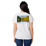 Person wearing a white t-shirt with a scenic print on the back