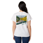 Person wearing a white t-shirt with a scenic graphic and text on the back