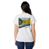 Person wearing a white t-shirt with a scenic graphic and text on the back