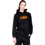 Person wearing a black hoodie with Halloween-themed design on a white background