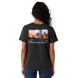 Person wearing a black t-shirt with a scenic print on the back, standing against a white background.
