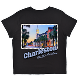 Black t-shirt with a colorful graphic of Charleston, South Carolina, featuring palm trees and buildings.