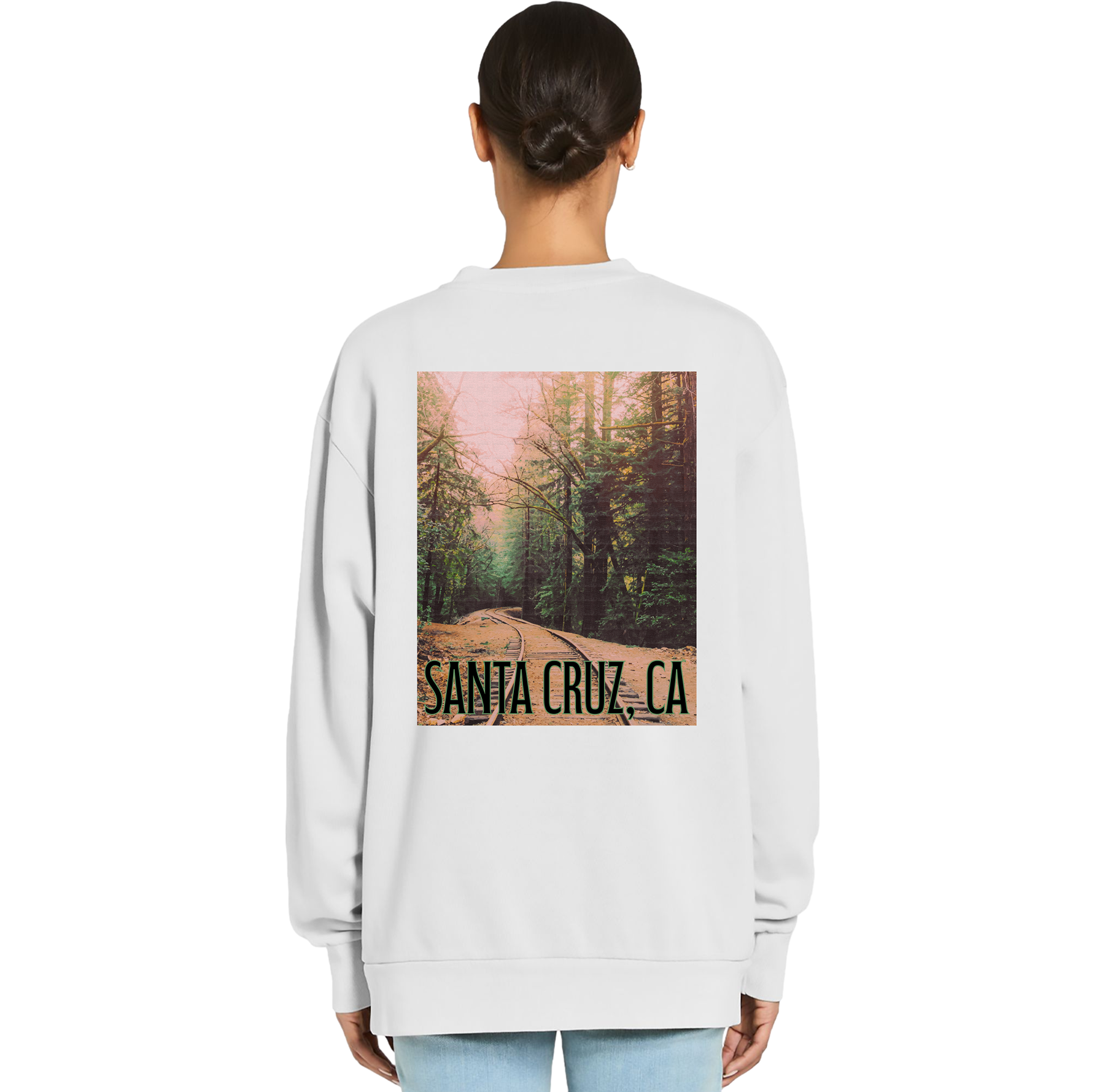 Person wearing a white sweatshirt with a graphic of a forest and 'Santa Cruz, CA' text on the back.