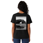 Person wearing a black t-shirt with a scenic print on the back