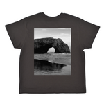 Black t-shirt with a black and white photo of a coastal arch on the front