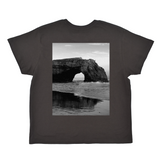 Black t-shirt with a black and white photo of a coastal arch on the front