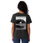 Person wearing a black t-shirt with a beach arch design on the back