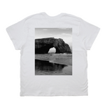 White t-shirt with a black and white photo of a coastal arch on the back