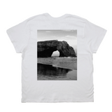 White t-shirt with a black and white photo of a coastal arch on the back