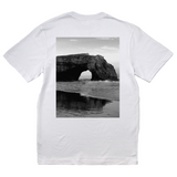 White t-shirt with a black and white graphic of a coastal arch on the back