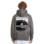 Person wearing a gray hoodie with a beach scene printed on the back