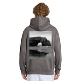 Person wearing a gray hoodie with a beach scene printed on the back