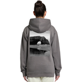 Person wearing a gray hoodie with a scenic print on the back, standing against a white background