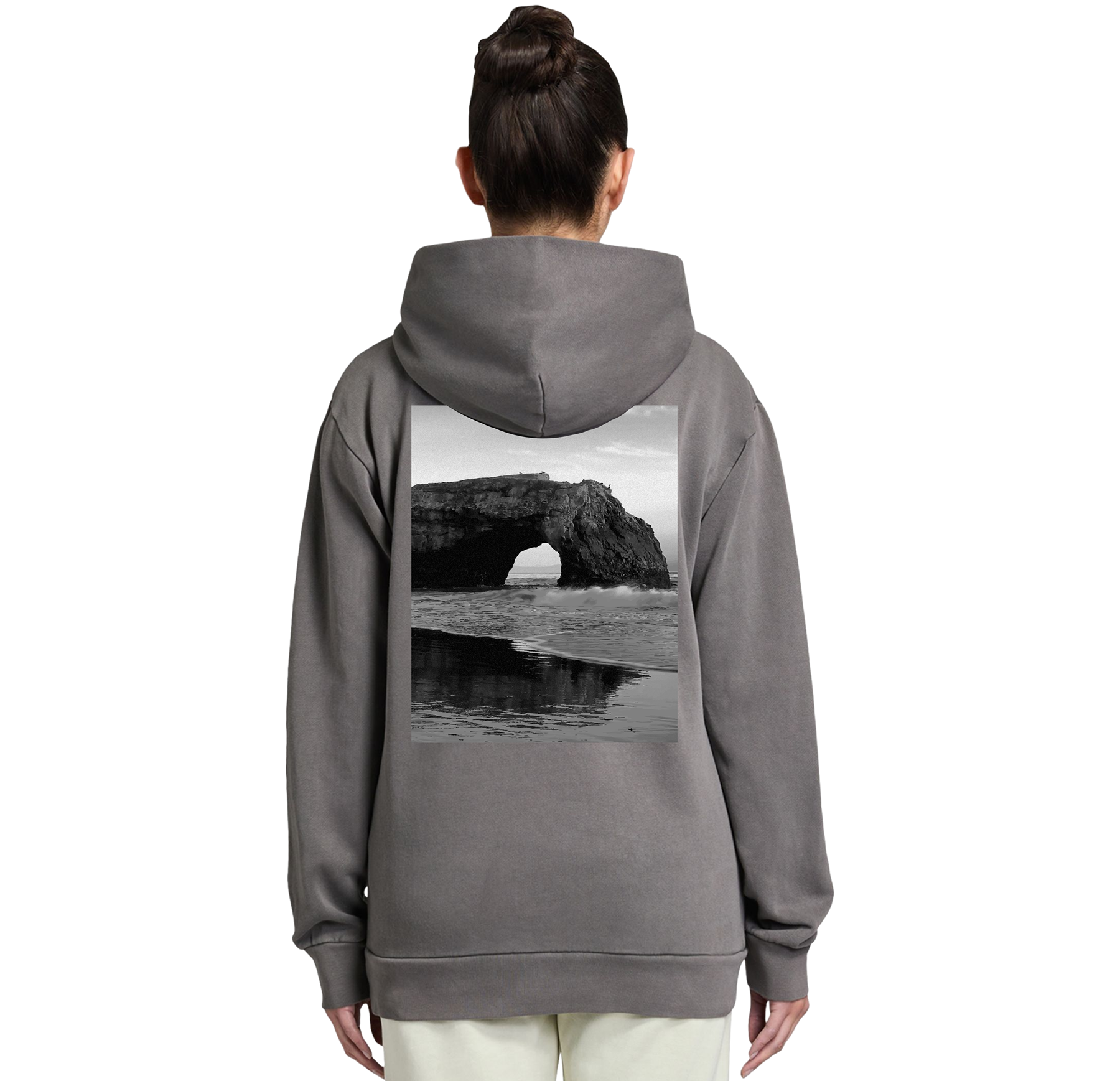 Person wearing a gray hoodie with a scenic print on the back, standing against a white background