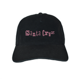 Black cap with pink 'Santa Cruz' text on a white background